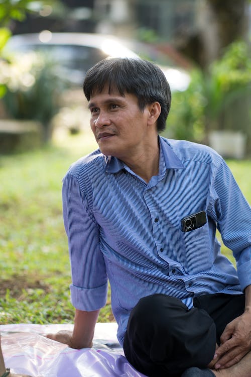 free-photo-of-portrait-of-a-man-wearing-a-blue-shirt-sitting-outdoors
